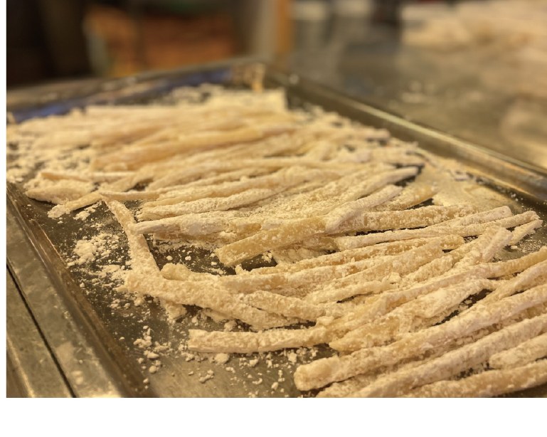 Hand-made cod fish noodles drying on a tray